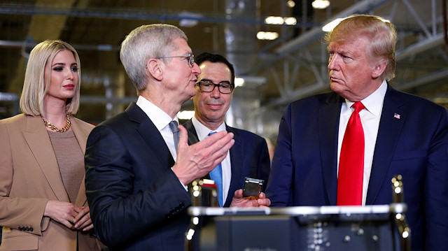 Apple CEO Tim Cook speaks with U.S. President Donald Trump as he tours Apple