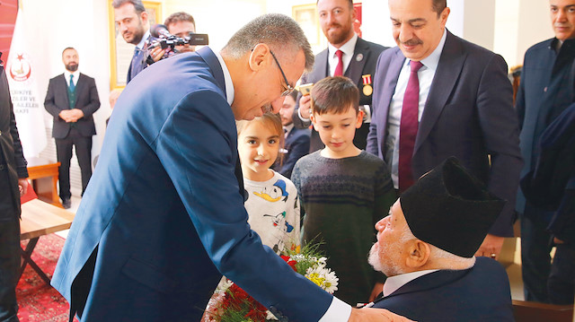 Cumhurbaşkanı Yardımcısı Fuat Oktay, şehit ve gazi çocukları tarafından kendisine verilen çiçeği, 93 yaşındaki Kore gazisi Zeynel Kavlak’a hediye etti.