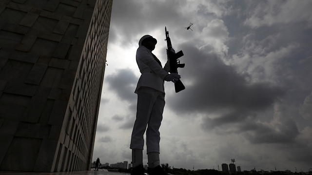 A cadet of the Pakistan Navy, positions with the backdrop of monsoon clouds during a ceremony to celebrate Pakistan's 72nd Independence Day and to express solidarity with the people of Kashmir, at the Mausoleum of Muhammad Ali Jinnah in Karachi, Pakistan August 14, 2019. REUTERS/Akhtar Soomro

