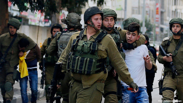 Bir Filistinliyi 5 İşgalci İsrail polisi tutukluyor.