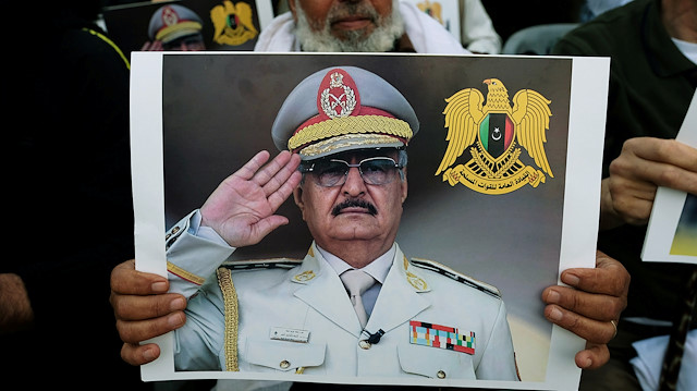 A Libyan man carries a picture of Khalifa Haftar during a demonstratio