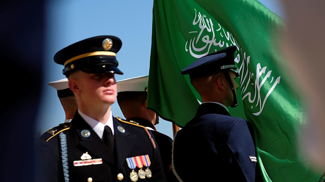The flag of the Kingdom of Saudi Arabia flies in the face of a member of a U.S. military honor guard awaiting the arrival of the Kingdom's Deputy Defense Minister Prince Khalid bin Salman at the Pentagon in Washington, U.S., August 29, 2019. REUTERS/James Lawler Duggan

