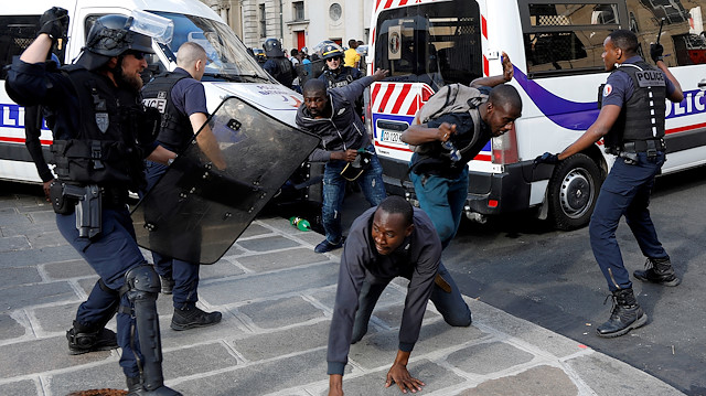 Riot police officers clash with undocumented migrants outside the Pantheon in Paris