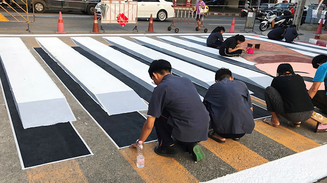 People paint a 3D pedestrian crossing in Bangkok, Thailand November 16, 2019