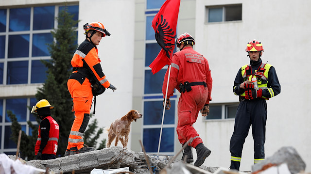 Rescue workers with a dog work on a collapsed building in Durres, after an earthquake shook Albania, November 29