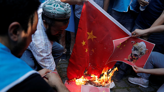Ethnic Uighur demonstrators set fire a Chinese flag during a protest against China in front of the Chinese Consulate in Istanbul, Turkey, October 1, 2019. REUTERS/Huseyin Aldemir

