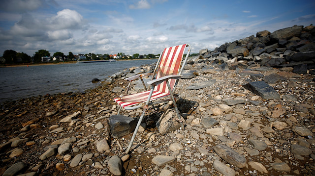 File photo: A lone camping chair stands in the river bed of the partially dried out river Rhine in Rhoendorf near Bonn, Germany, August 17, 2018, as water levels reached a historic low level and freight vessels cannot sail fully loaded on the river
