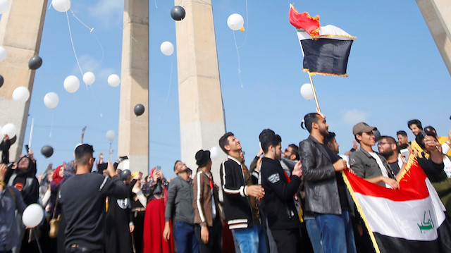 University of Basra students carry balloons as they take part in an anti-government protest