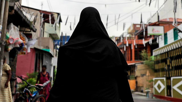 A Muslim woman wearing a hijab walks through a street near St Anthony's Shrine