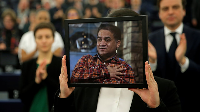 Jewher Ilham, daughter of Ilham Tohti, Uyghur economist and human rights activist, holds a portrait of her father during the award ceremony for his 2019 EU Sakharov Prize at the European Parliament in Strasbourg, France, December 18, 2019. 