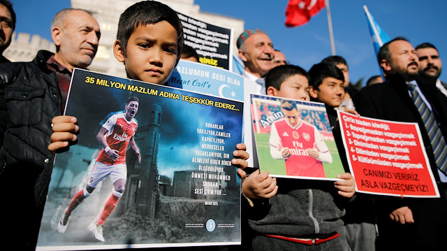 Ethnic Uighur boys hold placards with the pictures of English soccer club Arsenal's midfielder Mesut Ozil during a protest against China in Istanbul, Turkey December 14, 2019. The placard reads: "Thank you, Mesut Ozil, on behalf of 35 million oppressed". REUTERS/Kemal Aslan NO RESALES. NO ARCHIVES

