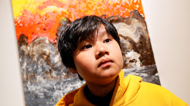 Xeo Chu, a Vietnamese art prodigy, poses in front of one of his pieces before his debut solo exhibition at the Georges Berges Gallery in New York City, New York, U.S., December 18, 2019. REUTERS/Shannon Stapleton

