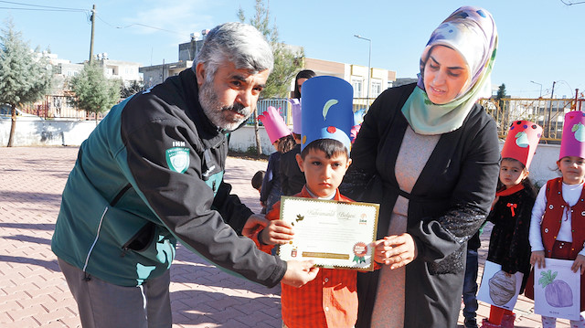 Küçük Mirza, kumbarasını İHH gönüllülerine teslim etti.