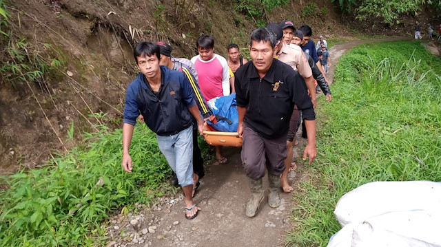 Endonezya'da meydana gelen kazadan sonra kurtarma işçileri yolcunun cesedini taşıyor.