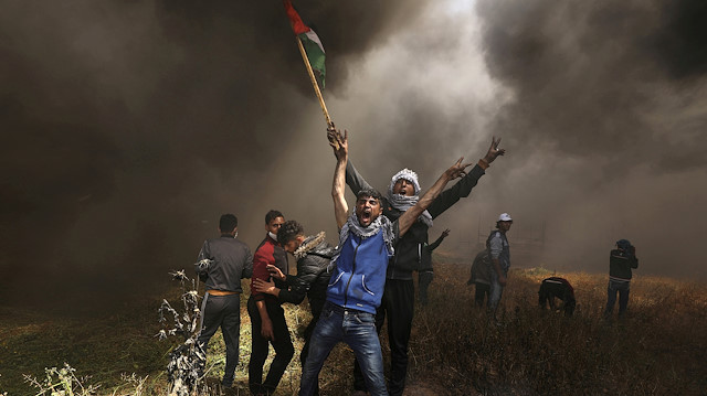 FILE PHOTO: Palestinian demonstrators shout during clashes with Israeli troops at a protest demanding the right to return to their homeland, at the Israel-Gaza border east of Gaza City April 6, 2018. REUTERS/Mohammed Salem/File Photo

