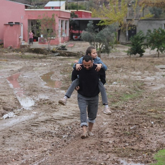 Adanada yol yapılmayınca okula giden çocuklarını sırtlarında taşıyorlar