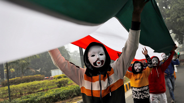 File photo: Demonstrators wearing masks hold a tricoloured flag in front of the India Gate during a demonstration against what they say was an alleged police action conducted during recent protests against a new citizenship law, in New Delhi, India, December 30