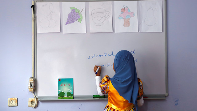 File photo: A girl writes, 'We, children of Turkestan, love our homeland' in the Uighur language in a classroom at a kindergarten for Uighur children in the Zeytinburnu district, which hosts most of the Uighur exiles, in Istanbul, Turkey, December 14, 2018