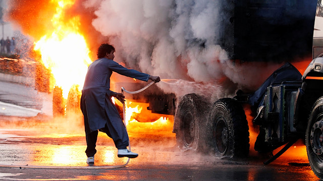 A man attempts to extinguish a burning truck which was hit by a magnetic bomb in Jalalabad, Afghanistan November 23, 2019. REUTERS/Parwiz

