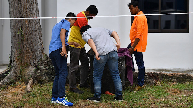 Police officers and cleaners inspect the contents of a bin at a rubbish chute, after a baby was found alive among rubbish in a bin at a public housing estate in Singapore, January 7, 2020. Lim Yaohui/The Straits Times via REUTERS 