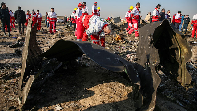 Arama kurtarma ekipleri düşen uçağın parçalarını inceliyor.