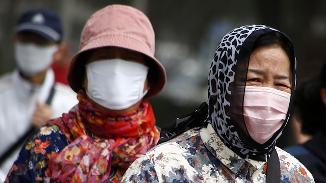 File photo: People wear face masks as a dust storm hits Beijing, China 