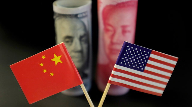 U.S. and Chinese flags are seen in front of a U.S. dollar banknote