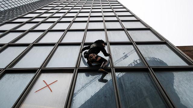 French climber Alain Robert, also known as "Spiderman", scales the Tour Total skyscraper in support of the anti pensions reform strikers at La Defense financial and business district near Paris, France