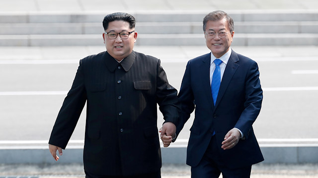 FILE PHOTO: South Korean President Moon Jae-in walks with North Korean leader Kim Jong Un at the truce village of Panmunjom inside the demilitarized zone separating the two Koreas, South Korea