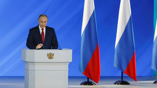 Russian President Vladimir Putin is seen on screen as he delivers his annual state of the natio