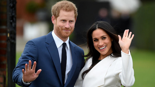 Britain’s Prince Harry waves next to his wife Meghan Markle