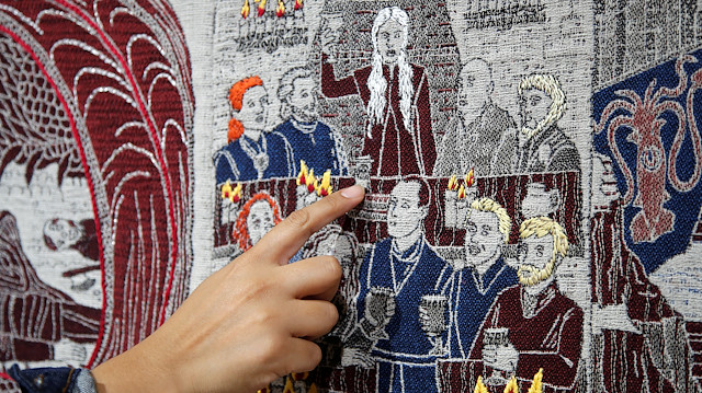 A visitor points at the Starbucks cup of the Game of Thrones Tapestry in Bayeux, France, September 13, 2019. The 87-metre-long tapestry work was made in Northern Ireland to honour the television series Game of Thrones is on display across the street from the better-known original 11th-century Bayeux Tapestry. REUTERS/Charles Platiau 

