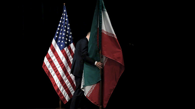  A staff member removes the Iranian flag from the stage after a group picture 