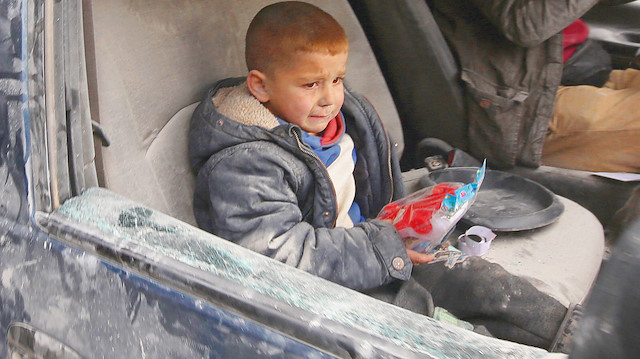 Yoldan geçen bir araç bombardımanda hasar gördü. Aracın içinde bulunan minik çocuk korkulu gözlerle etrafa bakarken elindeki oyuncağı bırakmadı.