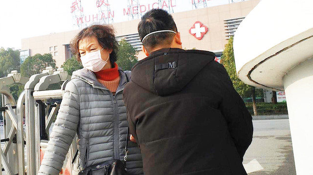 Çin sokaklarında hastalıktan korunmak için maske kullanılıyor.