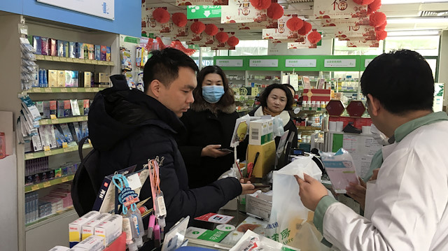A man pays for masks at a pharmacy in Beijing, China 