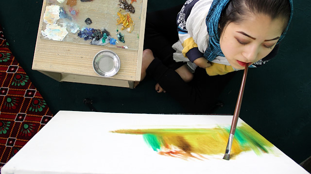 فتاة أفغانية من ذوي الاحتياجات الخاصة تبدع بالرسم بفمها