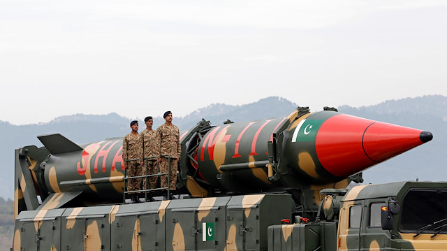 Pakistani military personnel stand beside a Shaheen III surface-to-surface missile