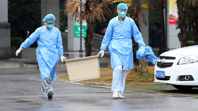 Medical staff carry a box as they walk at the Jinyintan hospital, where the patients with coronavşrus are being treated