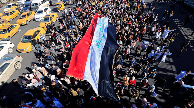 University students carry an Iraqi flag, during ongoing anti-government protests in Baghdad, Iraq January 26, 2020. REUTERS/Thaier al-Sudani  