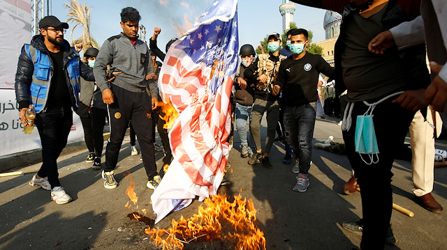 Supporters of Qais al-Khazali, leader of the Asaib Ahl al-Haq Iran-backed militia group, burnt an U.S. flag during a demonstration against U.S sanctions targeting al-Khazali, in Baghdad, Iraq, December 14, 2019. REUTERS/Alaa al-Marjani

