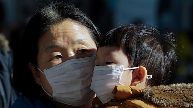 A mother and her child wear a mask to prevent contacting a new coronavirus in Seoul, South Korea, January 26, 2020. Yonhap via REUTERS