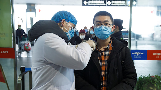 File photo: A medical official takes the body temperature of a man at the departure hall of the airport in Changsha, Hunan Province, as the country is hit by an outbreak of a new coronavirus, China, January 27, 2020. 
