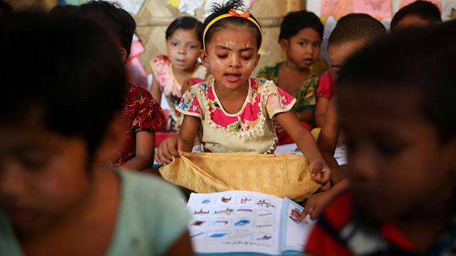 Rohingya refugee children attend a class to learn Burmese language at a refugee camp