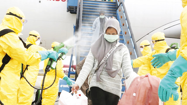 Endonezya’da sağlık ekipleri Vuhan’dan gelen yolcuları spreyle dezenfekte etti.