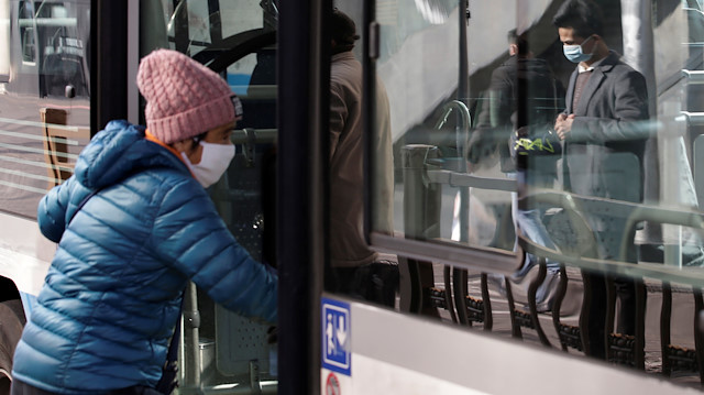 A woman wearing a mask gets on a bus near Beijing West Railway Station in Beijing, China, as the country is hit by an outbreak of the new coronavirus, January 30, 2020. Picture taken January 30, 2020. REUTERS/Jason Lee