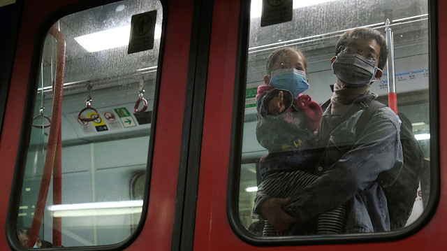 Passengers wear face masks in a Hong Kong bound MTR train at Lo Wu MTR station