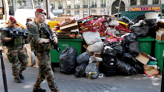 
File photo of soldiers pass by a pile of rubbish bags on the Grands boulevards in Paris, France, during a strike by garbage collectors and sewer workers of the city of Paris to protest the labour reforms law proposal, June 9, 2016. 