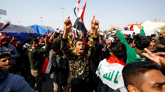 Iraqi demonstrators chant slogans during ongoing anti-government protests in Najaf