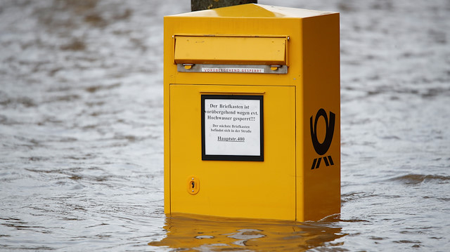 A mailbox is seen in flood water of the river Rhine in Koenigswinter, south of Bonn, Germany, February 6, 2020. The sign reads "this is mailbox might be out of order temporarily due to flood". REUTERS/Wolfgang Rattay

